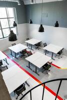 Modern office workspace featuring tables and chairs in a bright, minimalist design photo