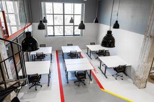 Modern workspace with multiple desks and large windows creating a bright atmosphere for collaboration photo