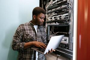 Technician configuring server settings in a data center during the day photo