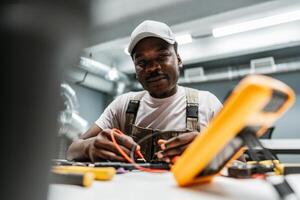 Skilled technician working on electrical equipment in a modern workshop setting photo