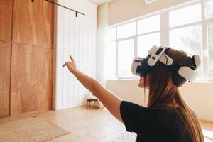 Woman experiences virtual reality in a bright indoor space during daylight hours while engaging with digital content photo