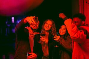 Group of friends celebrating with drinks and laughter at a nighttime gathering photo