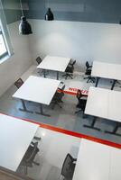 Modern coworking space with multiple workstations and ergonomic chairs in a well-lit environment photo