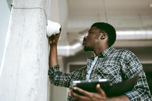 Technician installs security camera in modern office building during daylight hours photo