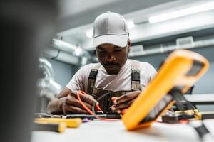 Electrician working diligently on a circuit board in a modern workshop during the daytime with various tools around photo