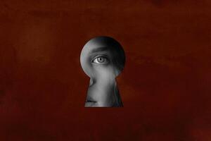 Mystical view through a keyhole revealing a woman's eye and emotion on a textured background photo