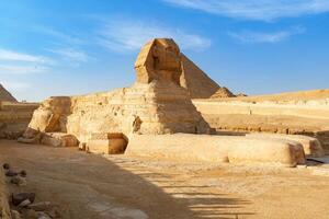 Sphinx stands majestically under clear skies at Giza in Egypt, showcasing ancient wonders photo