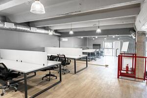 Modern coworking space with desks and chairs in a well-lit office environment on a bright day photo