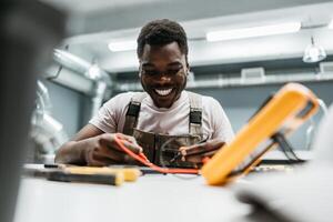 Skilled technician working with tools in a workshop environment during the day, showing enthusiasm and focus on the task at hand photo