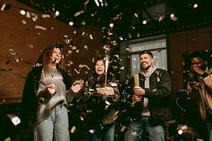 Friends celebrate with cake and confetti during a joyful gathering at a cozy venue in the evening photo