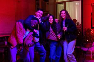 Group of friends enjoying a joyful evening at a lively social gathering in a cozy venue with colorful lighting photo