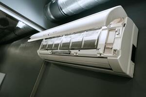Efficient wall-mounted air conditioning unit installed in a modern indoor space for optimal cooling comfort photo