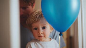 Child holds blue balloon while parent watches in cozy indoor setting during afternoon photo