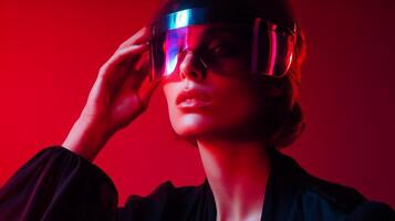 Stylish woman wearing futuristic visor in vibrant red lighting during a creative photoshoot at night photo