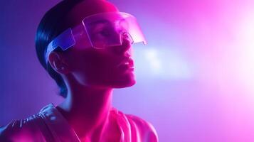 Model poses in futuristic glasses illuminated by vibrant purple and pink lights during a creative photoshoot in a studio setting photo