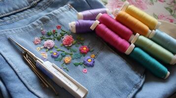 Stitching bright floral embroidery on denim fabric with colorful threads and tools in a creative workspace photo