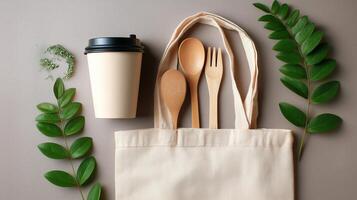 Stylish reusable tote bag with utensils and a coffee cup on a neutral background showcasing eco-friendly choices photo
