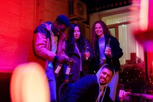 Friends enjoying a lively gathering with drinks and laughter in a warm, colorful setting during the evening hours photo