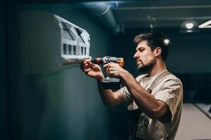 Man installs wall-mounted shelf in a modern indoor space using a power drill photo