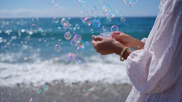Bubbles float in the air as a person enjoys a sunny day at the beach by the ocean in the afternoon light photo