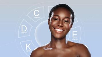 Smiling woman showcasing skincare benefits of vitamins C, D, E, and K in a minimalist setting photo