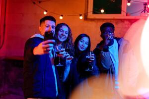 Friends celebrating with drinks in a vibrant outdoor setting during the evening hours photo