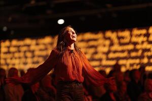 Performer expresses joy and energy on stage in front of an engaged audience during a nighttime event photo