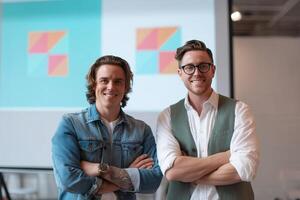 Two friends stand confidently in front of a colorful presentation during a business meeting in a modern office space photo