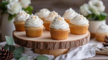 Delicious vanilla cupcakes topped with cream frosting on a rustic wooden cake stand in a cozy setting photo