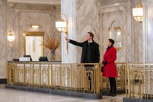 Couple exploring an elegant lobby of a historic building on a chilly afternoon in the city photo