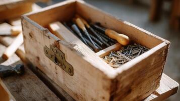 Wooden toolbox filled with various tools and screws set on a workbench in a workshop during daylight photo