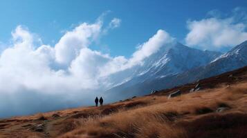 Two hikers explore a scenic mountain trail under a clear blue sky with wispy clouds in the early afternoon light photo