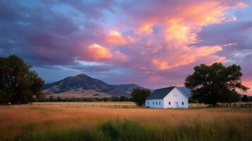 Sunset illuminates a serene white farmhouse against vibrant skies in a tranquil rural setting photo