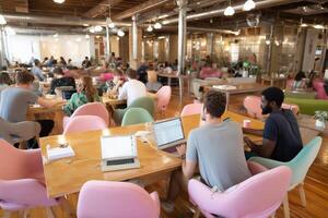 Modern coworking space filled with people collaborating and working on laptops during daytime photo