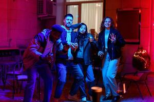 Friends enjoying a lively party with colorful lights and drinks on a festive evening photo