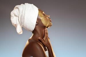 Relaxing skin treatment session featuring a woman applying a golden face mask in a serene setting photo