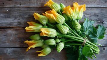 Freshly picked zucchini flowers arranged on rustic wooden table showcasing vibrant colors of spring harvest photo