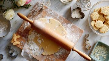 Baking cookies with dough, rolling pin, and cookie cutters on a marble countertop in a well-lit kitchen photo