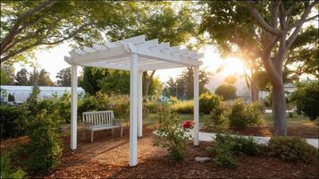 Tranquil garden setting featuring a white pergola and a bench during golden hour in a peaceful landscape photo