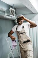 Worker smiling while standing on a ladder in a modern workspace during the day photo