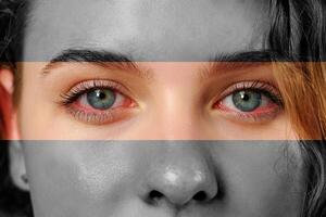 Close-up portrait of a person with striking blue eyes and grayscale effects in a creative artistic representation photo