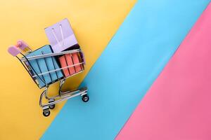 A shopping cart with a bunch of books on a colorful background photo