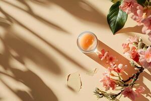 A jar of lip balm on a table with pink flowers photo
