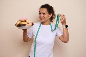Woman Balancing Healthy Choices and Indulgence with Plate of Doughnuts and Measuring Tape photo