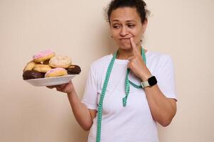 Woman Debating Between Sweet Doughnuts and Healthy Choices Featuring Wellness Awareness photo