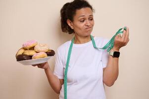 Woman Contemplating Donuts While Holding a Measuring Tape in a Health and Wellness Concept photo