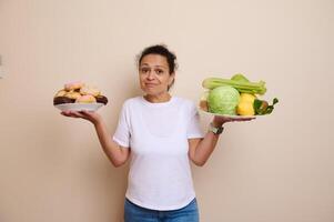Woman Contemplating Between Sugary Doughnuts and Fresh Healthy Fruits and Vegetables photo