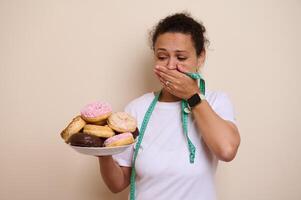Woman Contemplating Doughnuts While Considering Healthy Lifestyle Choices photo