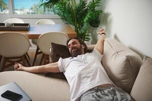 Man Relaxing on a Comfortable Couch in a Minimalist Home Setting photo