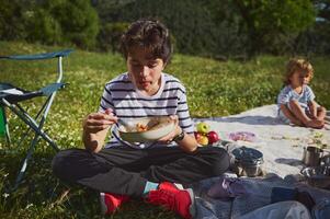 Family Enjoying a Relaxing Picnic with Healthy Snacks in a Scenic Natural Setting photo